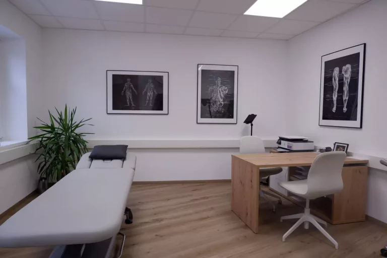 Physio Plus Therapieraum mit Behandlungsliege, Schreibtisch und Sessel